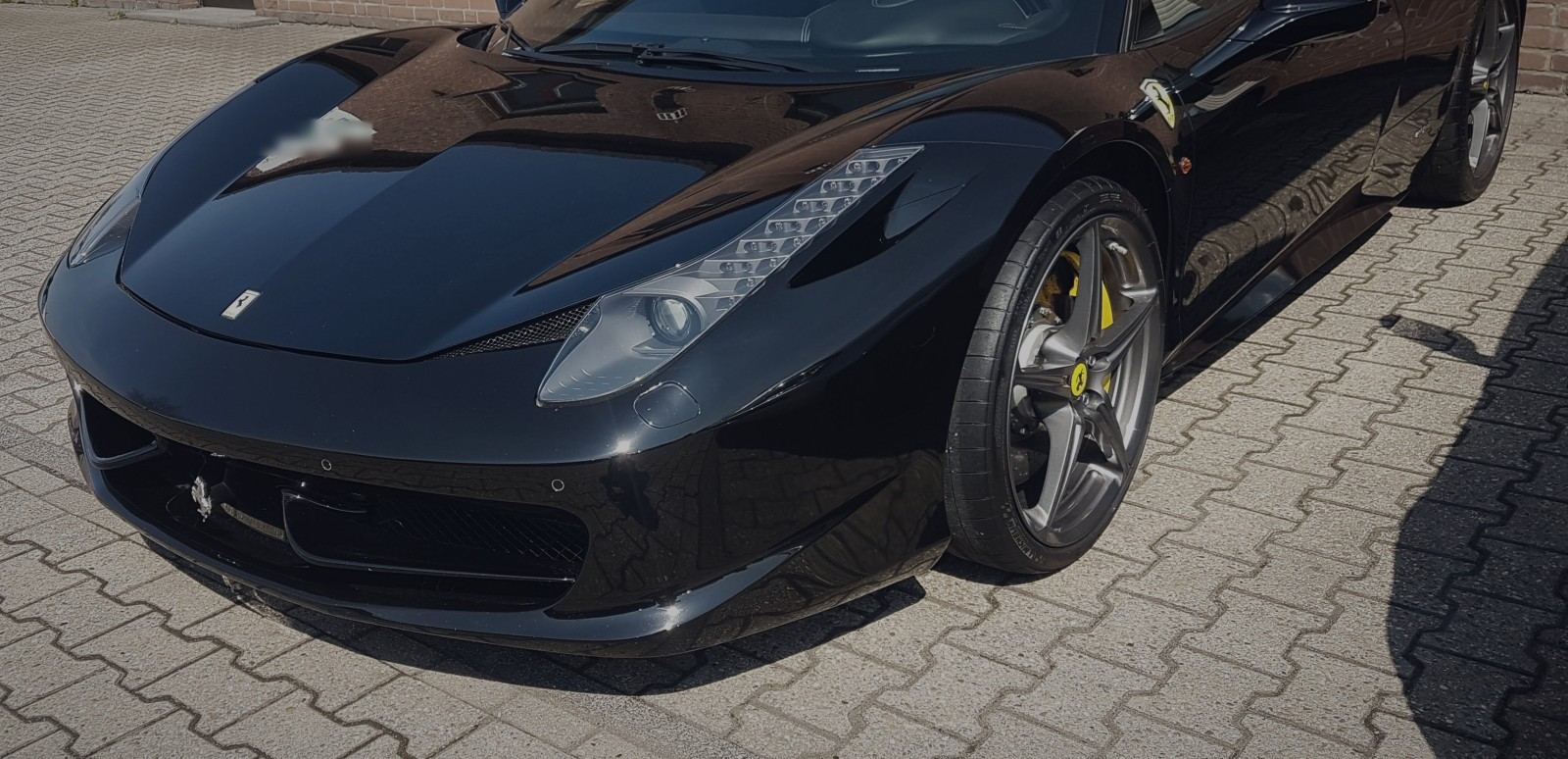 Schwarzer Ferrari 458 nach der Aufbereitung auf dem CarNCare-Hof